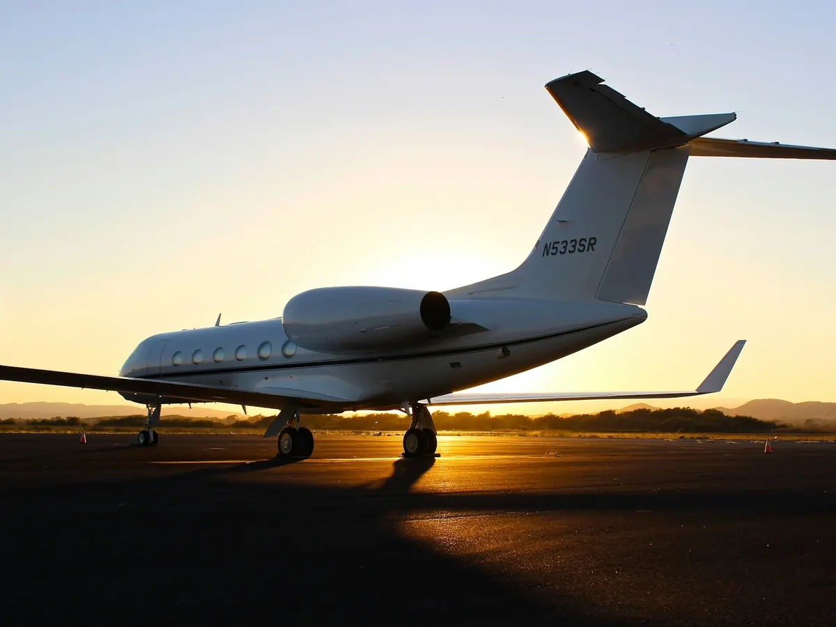 A Gulfstream silhouetted against an orange sunset