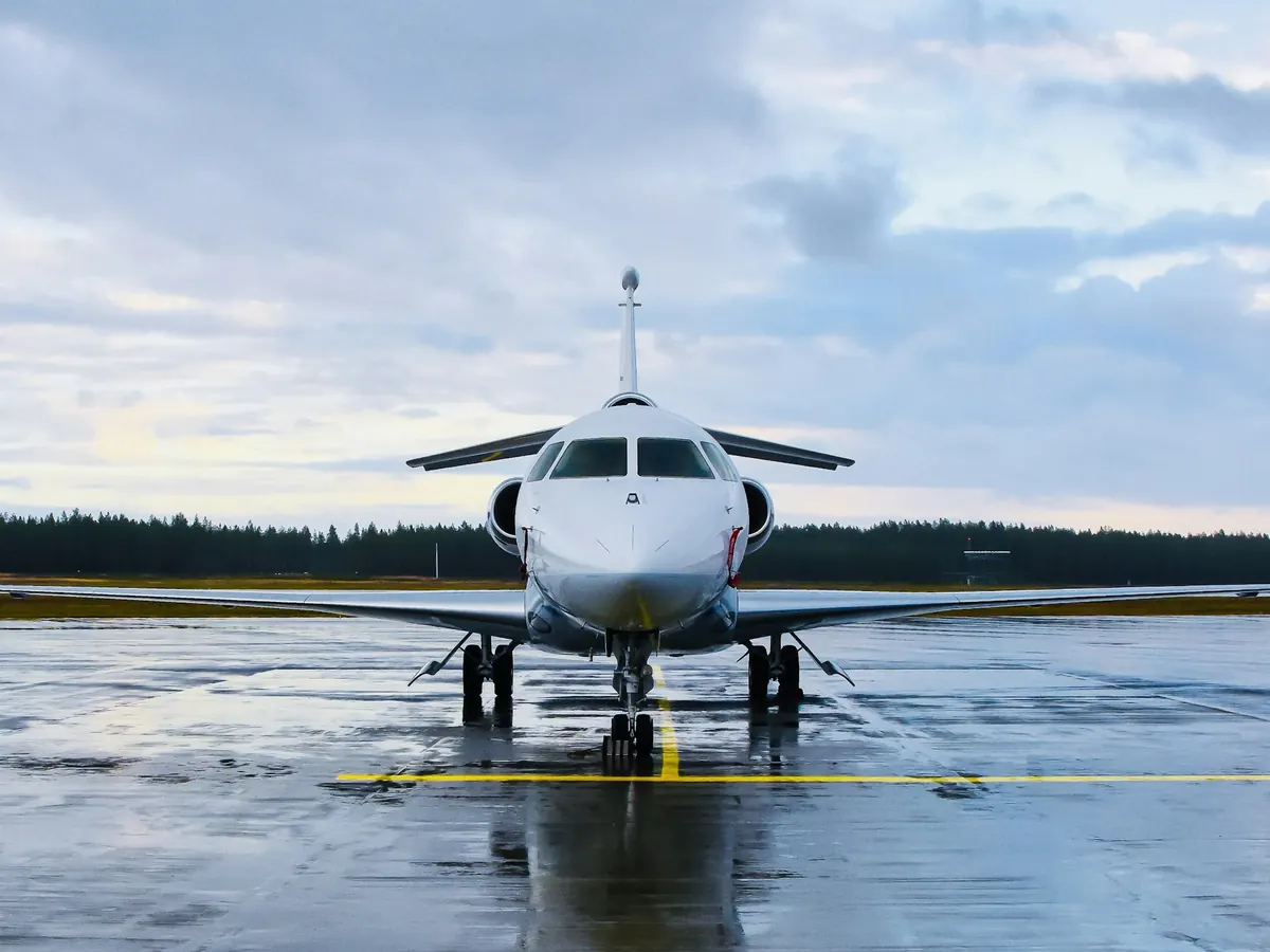 A business jet on a wet runway under gray skies