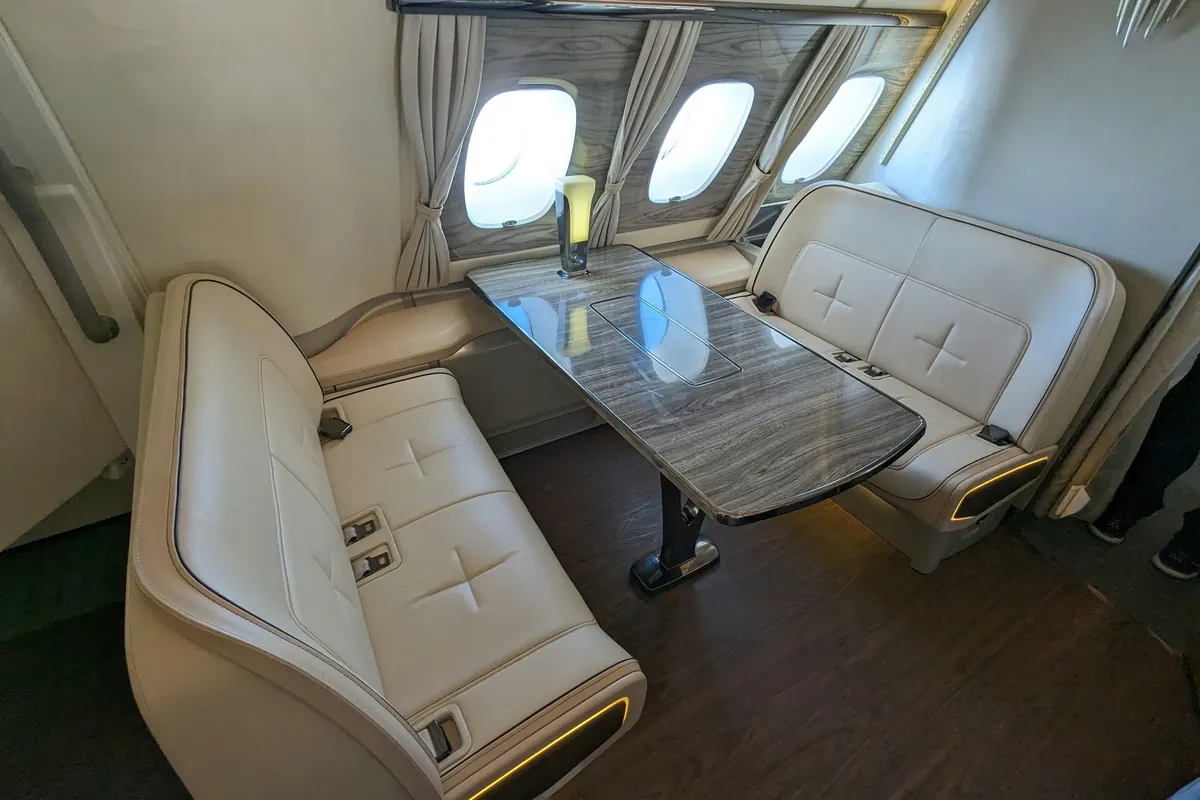 A private jet cabin with club seating and a table